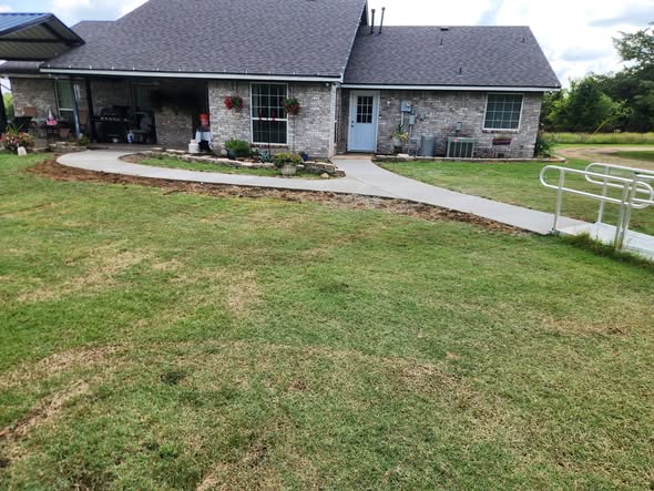 Curved concrete walkway around a home